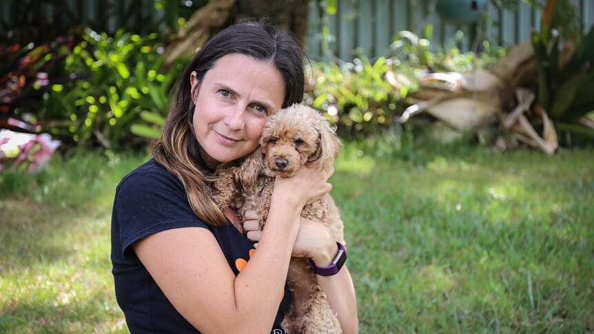 Woman cuddling dog