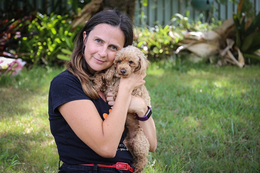 Woman cuddling dog