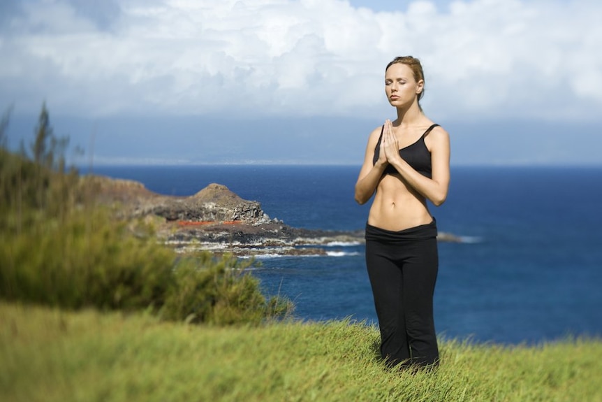 A woman meditating near the sea