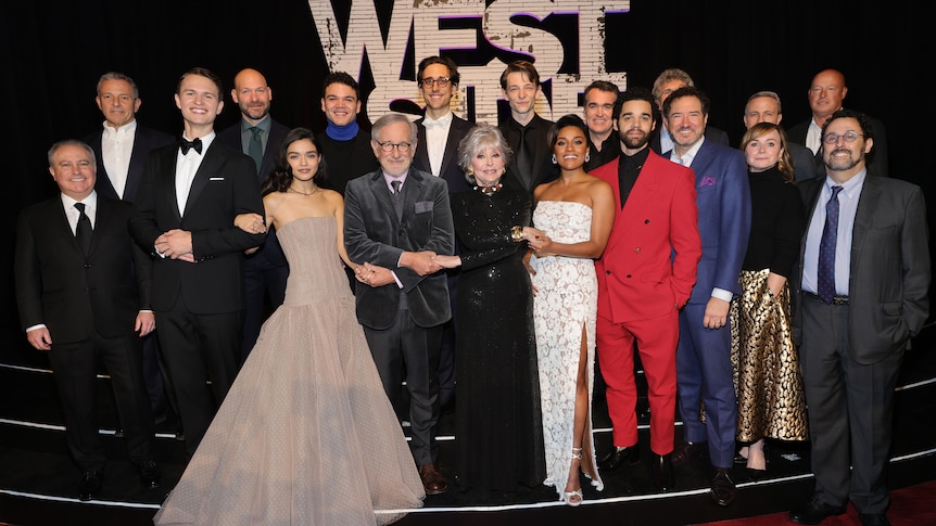 A group of people dressed in suits and gowns