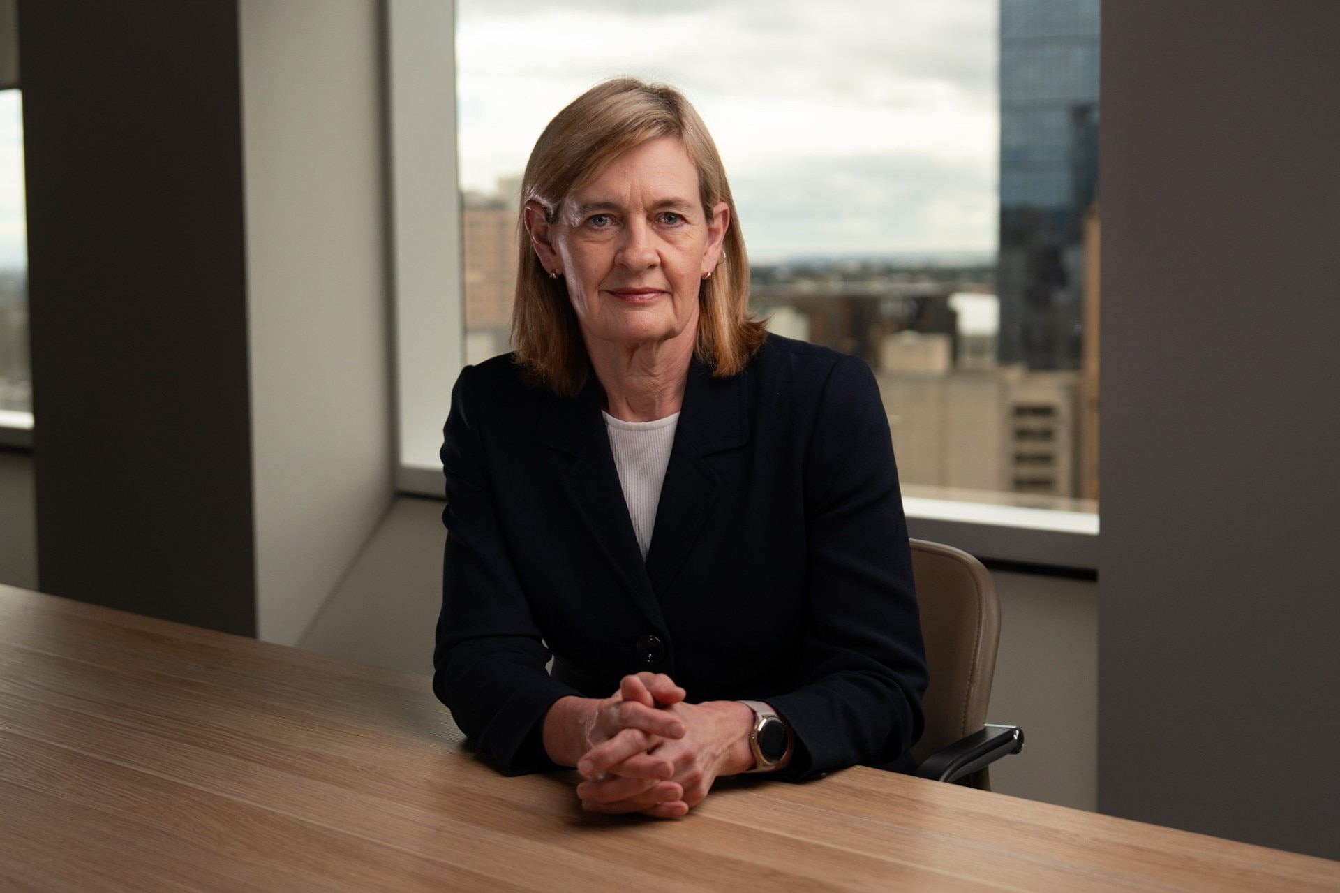 ASIC chair Sarah Court dressed in a blazer and white shirt sits at a conference table.
