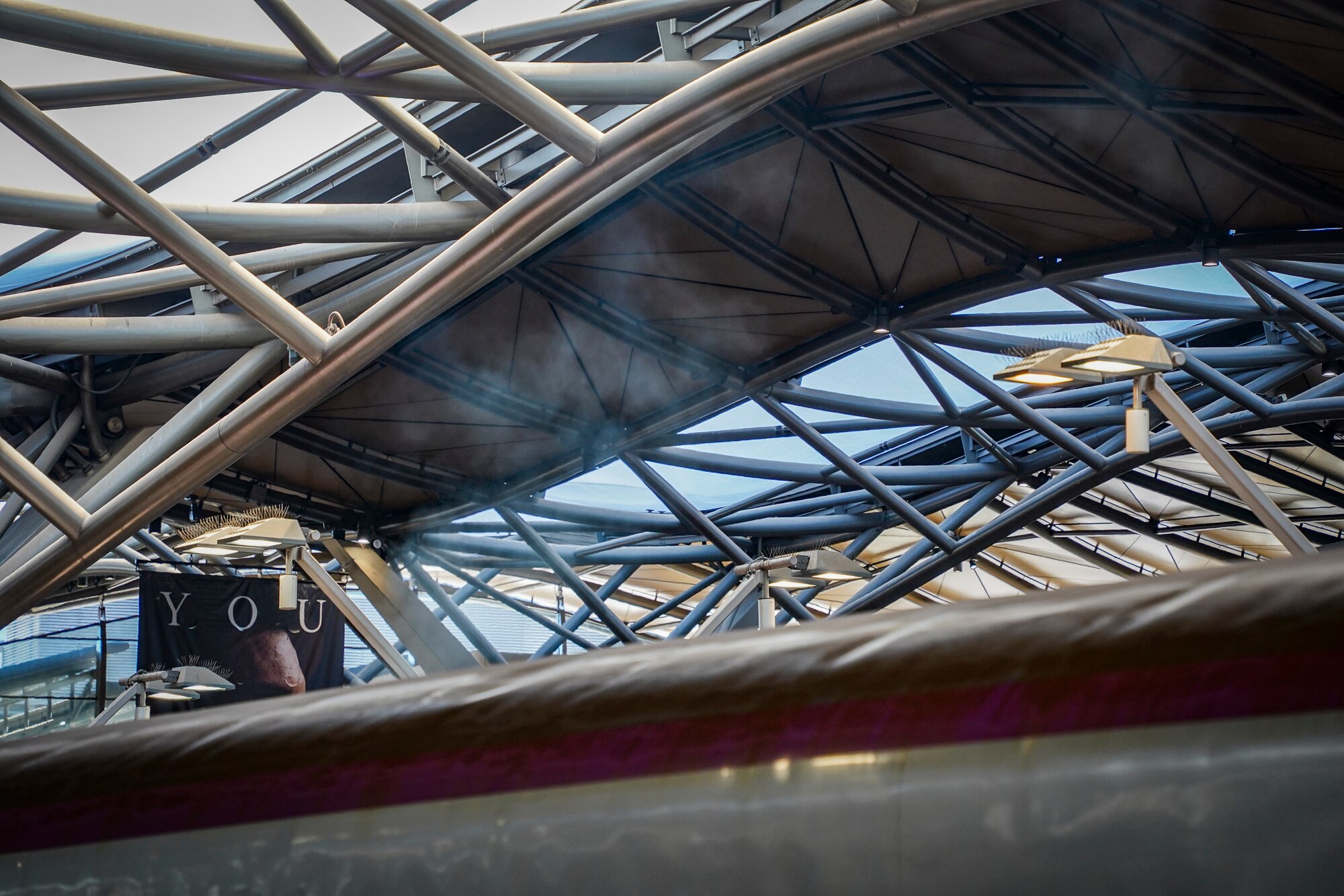 A photo of a white steam rising above a train