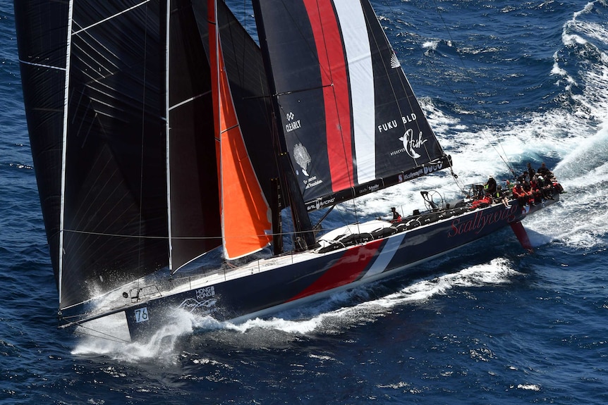 Scallywag, a large black-and-red yacht, is seen during the start of the Sydney to Hobart race.