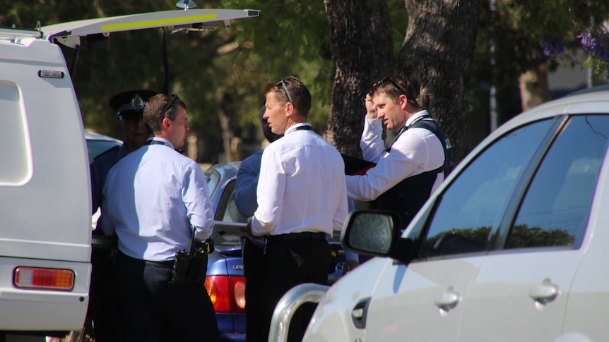 police stand between cars and near a tree after a shooting in Nollamara