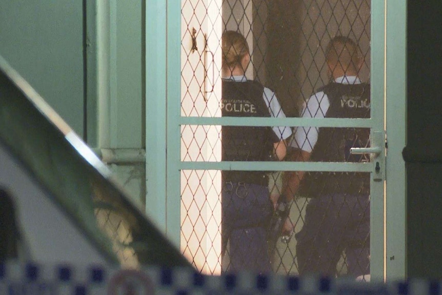 two police officers from the back inside a home