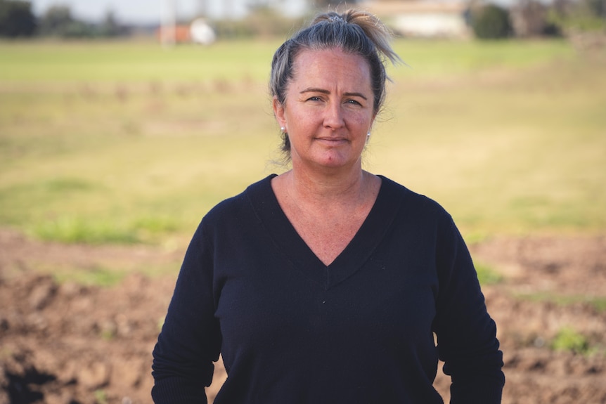 A woman stands in front of her turf farm