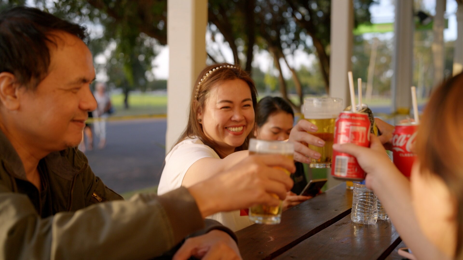 A group of people cheers drinks at a pub table