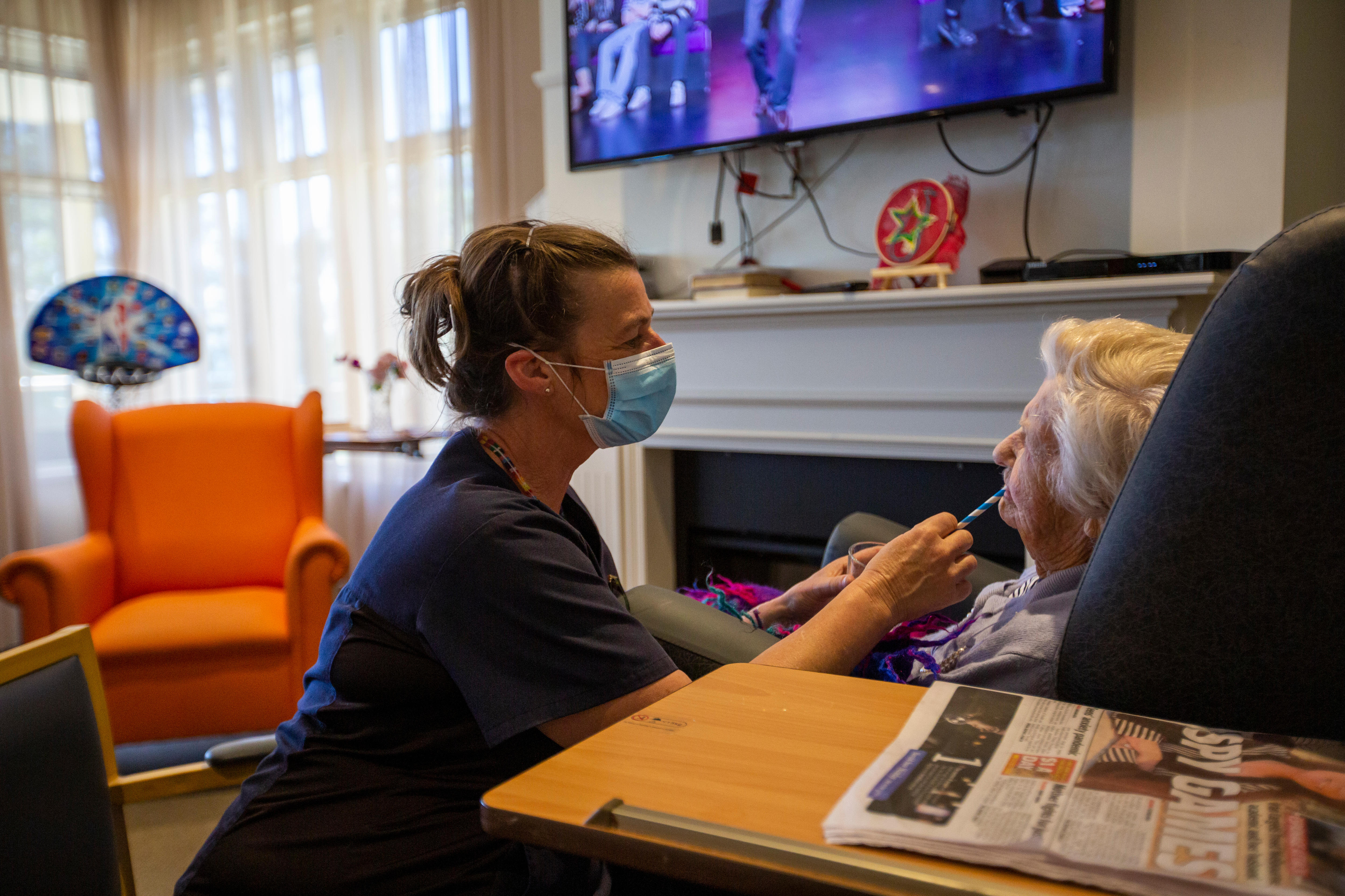 A nurse gives a covid test to an elderly lady