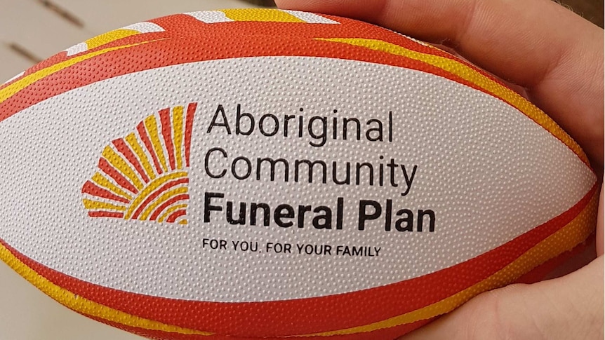 A yellow, orange and white mini rugby ball with branding of a funeral insurer