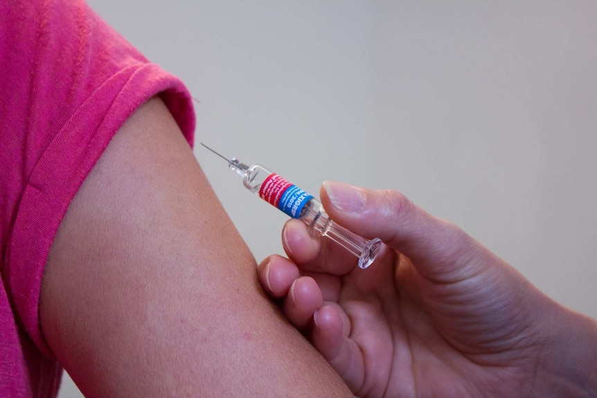A child's arm about to get an influenza vaccination