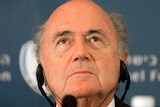A headshot of Sepp Blatter listening at a press conference.