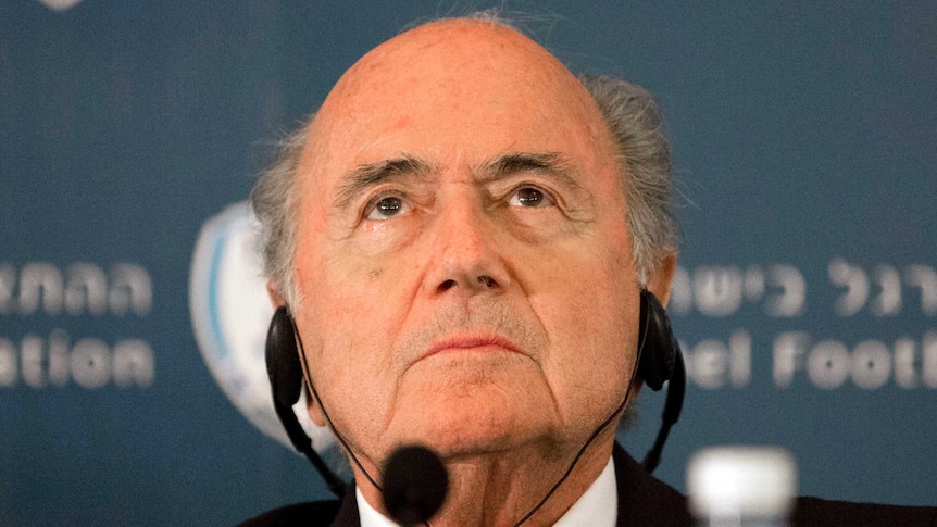 A headshot of Sepp Blatter listening at a press conference.