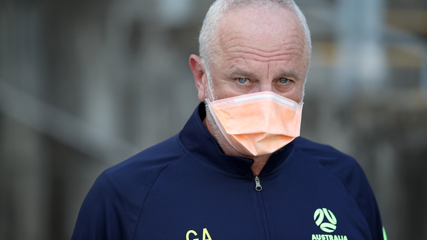 Graham Arnold wears a mask