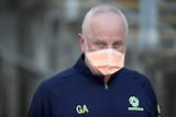 Graham Arnold wears a mask