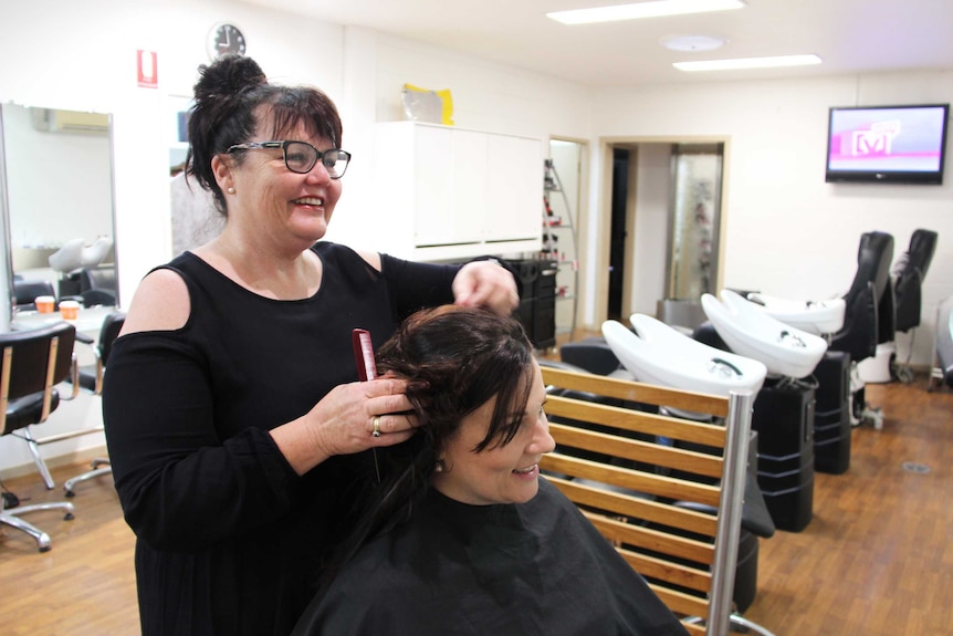 A hairdresser and client in a salon.