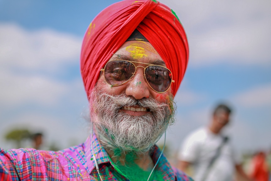 Guri Singh with coloured power all over his face, beard and clothes at a Holi festival in Melbourne.