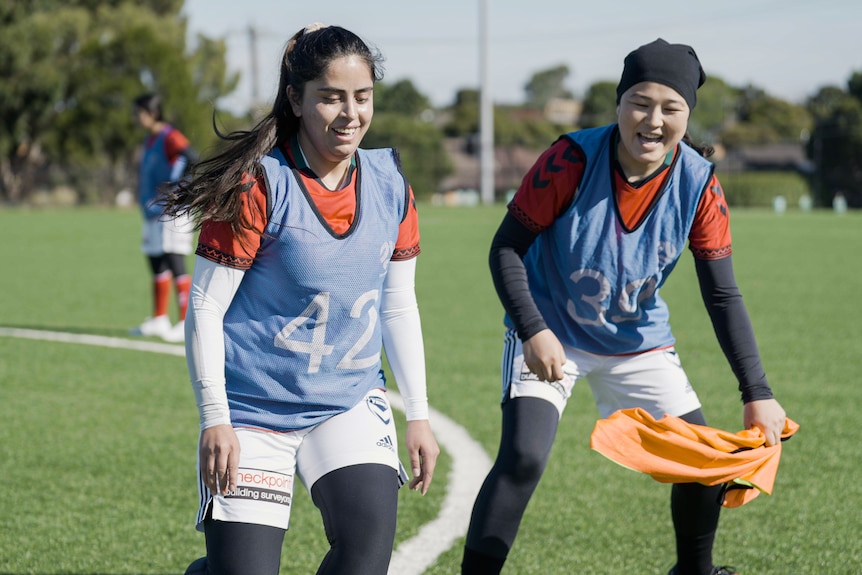 Two women from the Afghan refugee women's team smiling at training