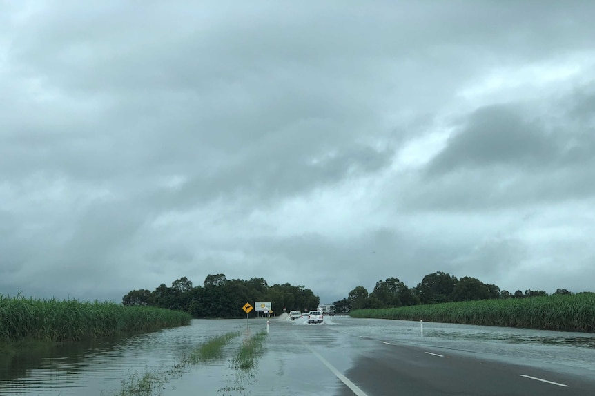 Cars drive through water over the road north of Ayr.