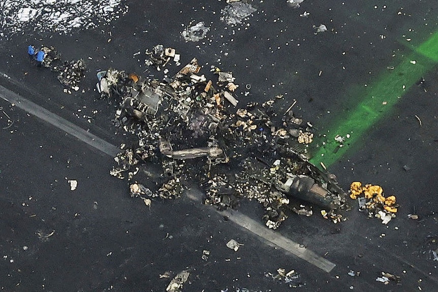 Aerial photo of wreckage on back tarmac of Tokyo's Haneda airport runway. Very little distinguishable