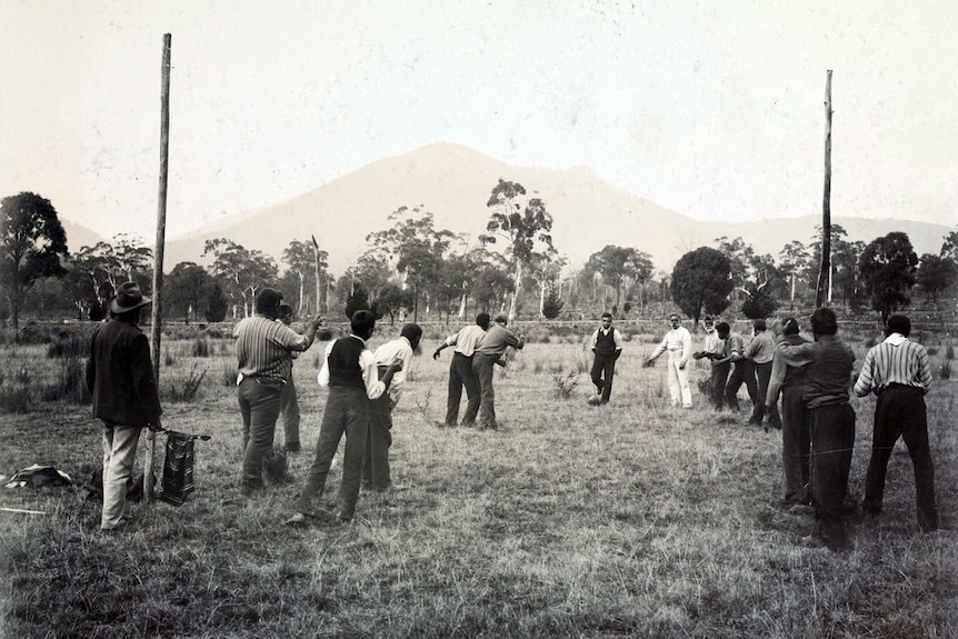 Photograph of Aboriginal men playing football in a paddock at Coranderrk Aboriginal Station, Victoria, 1904.