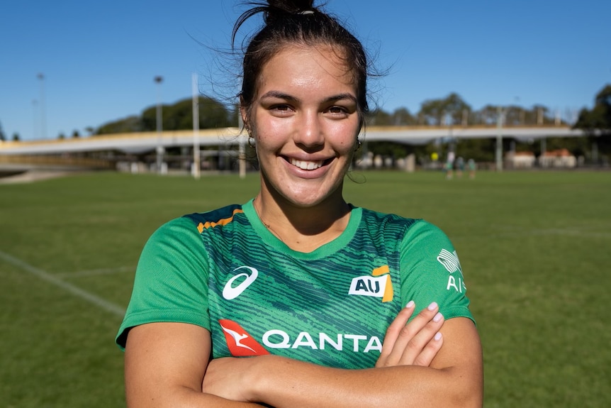Australian women's rugby sevens player Madison Ashby smiles at the camera with her arms folded.