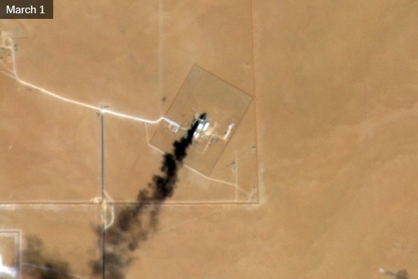 A satellite image of land with smoke rising.