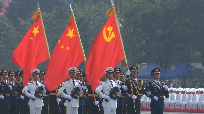 Soldiers carry flags in China.