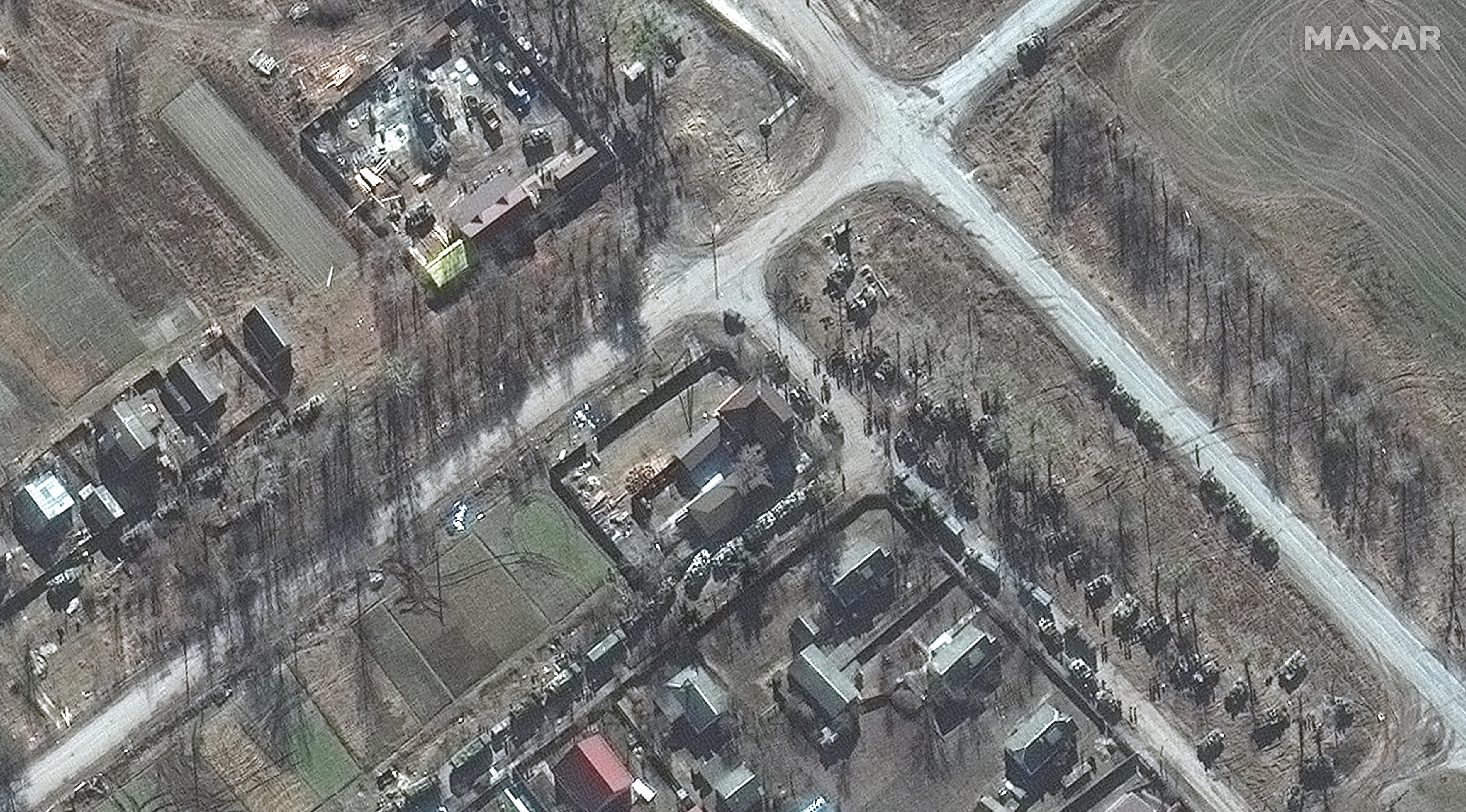 A close up showing soldiers getting out of trucks in a residential area in Ukraine.