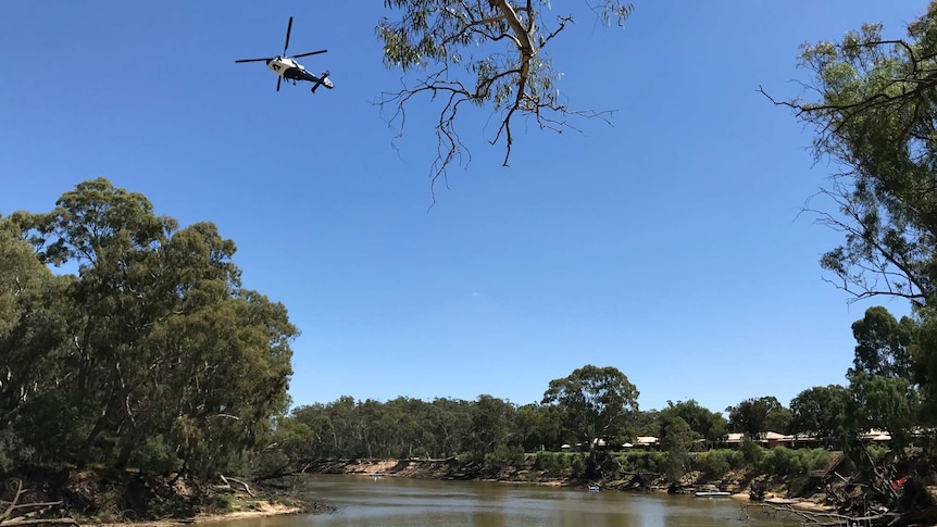 Helicopter hovering above the river.