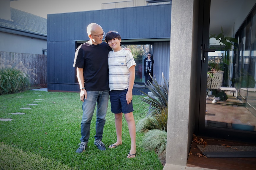 A man and a boy stand next to each other on green grass, in a story about house design for multi-generation families.