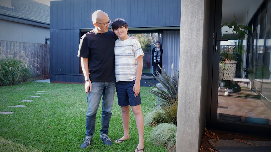 A man and a boy stand next to each other on green grass, in a story about house design for multi-generation families.