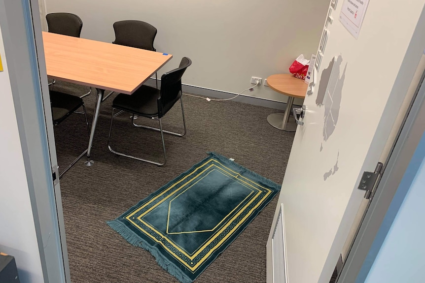 A Muslim prayer rug on the floor in a small office meeting room