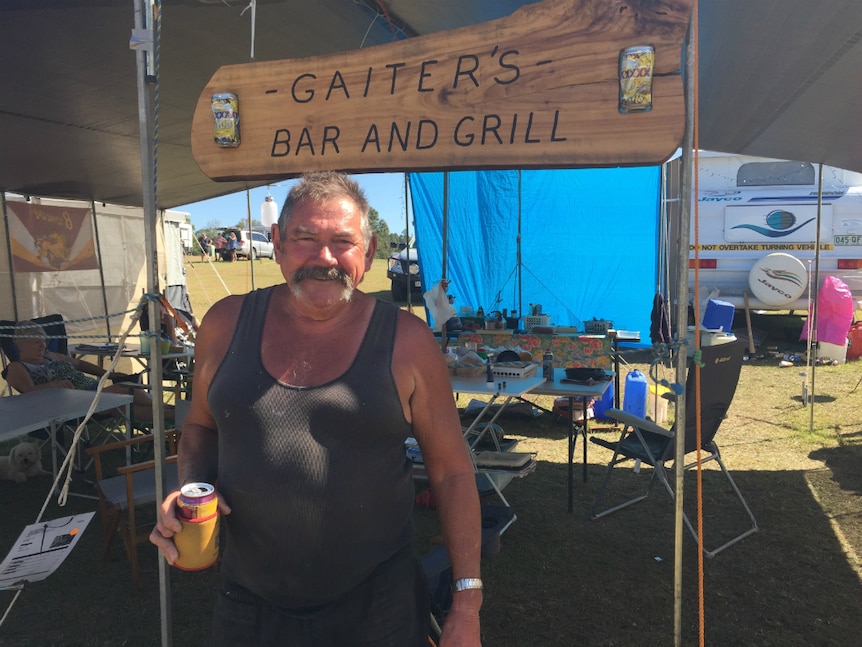 man standing smiling at a campsite in front of a sign that says Gaiter's Bar and Grill