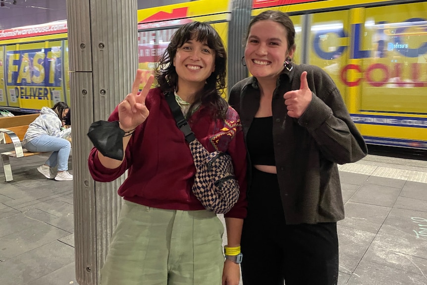 The author looks excited and fangirly, giving a thumbs up next to her favourite artist, who's doing a peace sign.