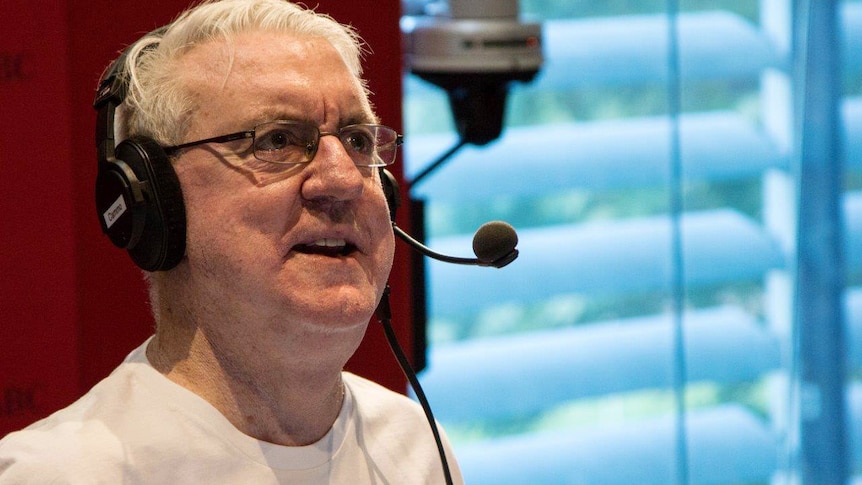 Eoin Cameron speaks into a microphone in the 720 ABC perth studios wearing a pair of headphones.