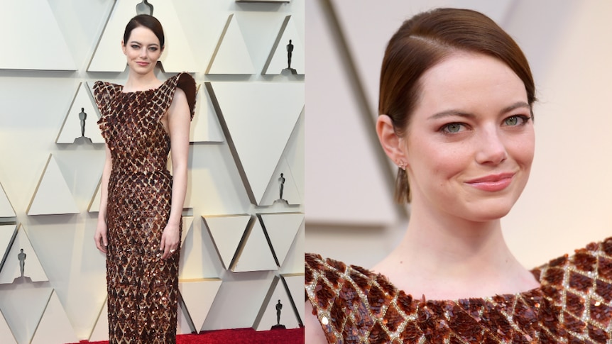 Emma Stone wears a red and orange, sequined dress with structured shoulders.