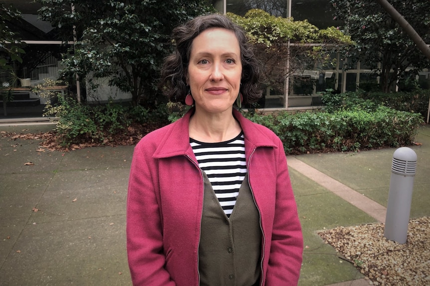 Alison Hetherington standing in a garden courtyard.