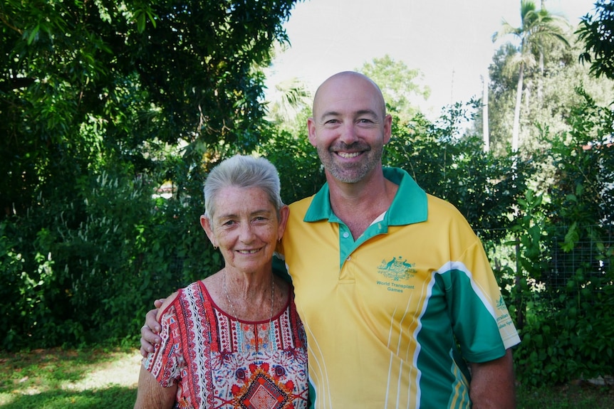 A woman and man stand next to each other, smiling at the camera. 