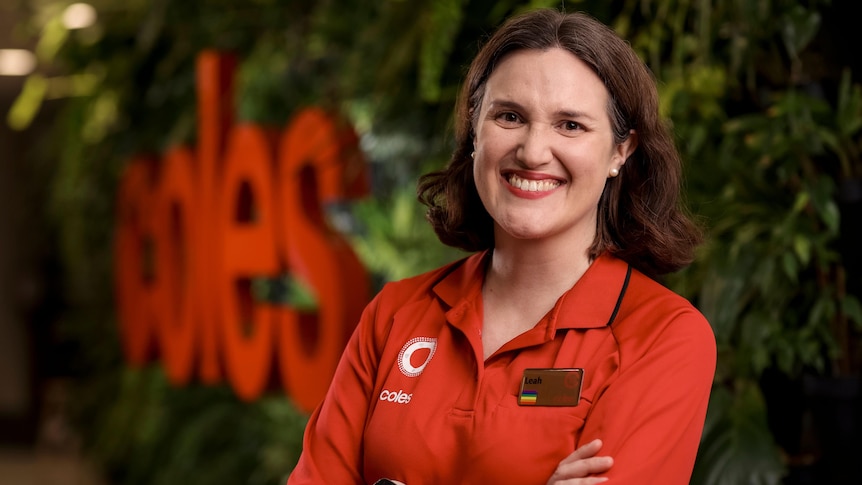 Incoming Coles CEO Leah Weckert stands in front of a Coles sign.