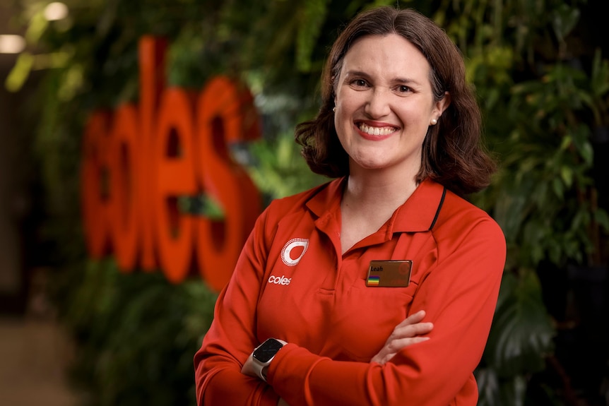Incoming Coles CEO Leah Weckert stands in front of a Coles sign.