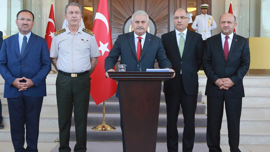 Turkish Prime Minister Binali Yildirim flanked by officials during a press conference in Ankara.