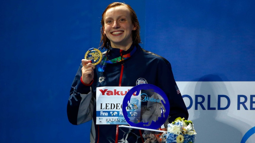 American Katie Ledecky poses with the gold medal after winning the 800m freestyle at world titles.