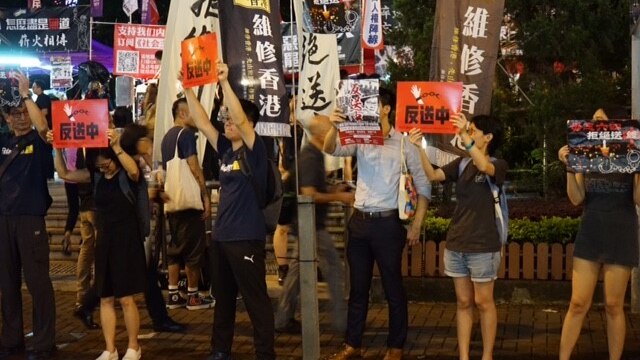 Protesters hold signs saying "No extradition to mainland China".