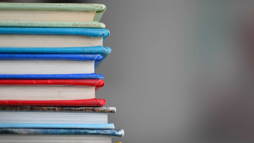 A side profile of stack of colourful books.