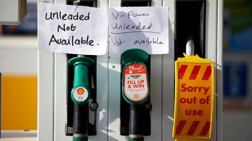 Hand written signs are stuck to a petrol pump with no fuel