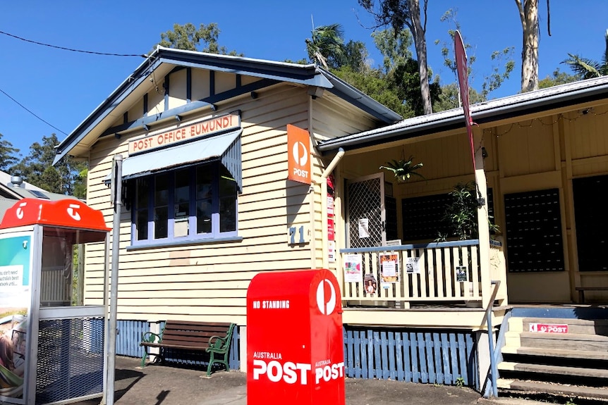 A street scene showing a timber post office cottage.