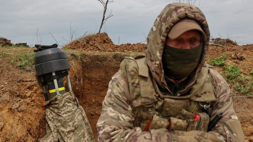 A Ukrainian soldier stands next to a Javelin anti-tank missile while standing in trench