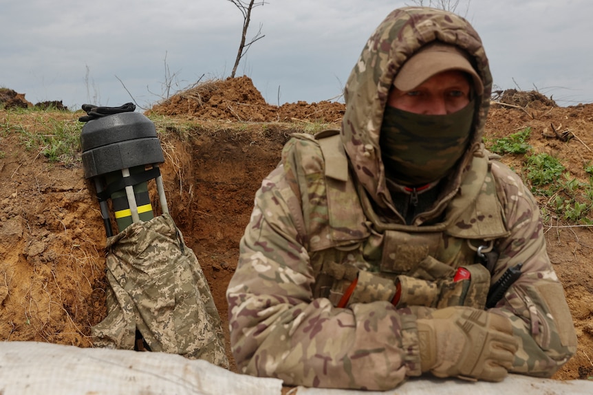A Ukrainian soldier stands next to a Javelin anti-tank missile while standing in trench