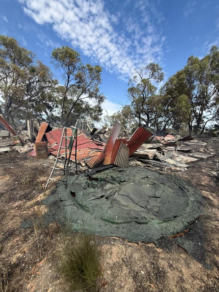 una estructura dañada y un pozo de ceniza circular en el suelo 