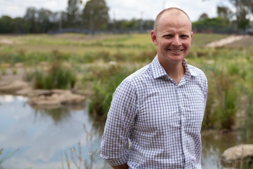 A man standing in a waterway.